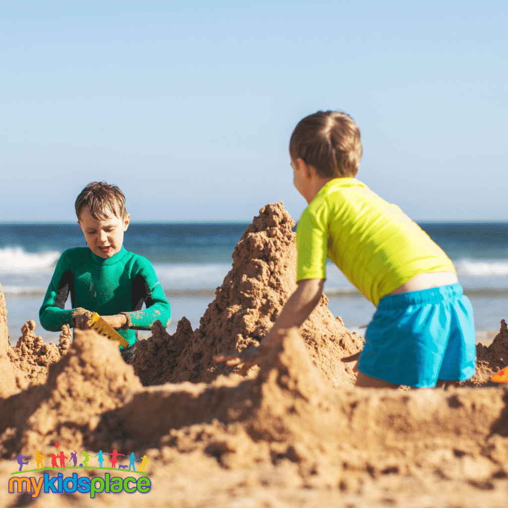 Two children work together to build a sandcastle