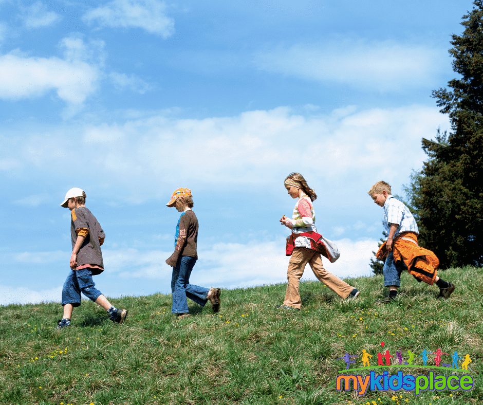 Four children walking across a grass field illustrate different stages of the gait cycle including stance phase, swing phase, toe-off, and initial strike.